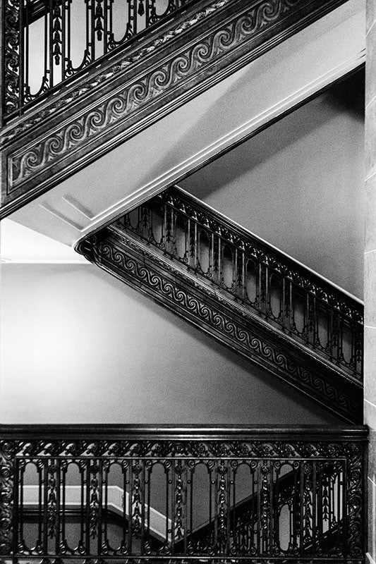 Black and white photographic composition of the ornate staircases inside the historic Wisconsin State Capitol building in downtown Madison, Wisconsin.
