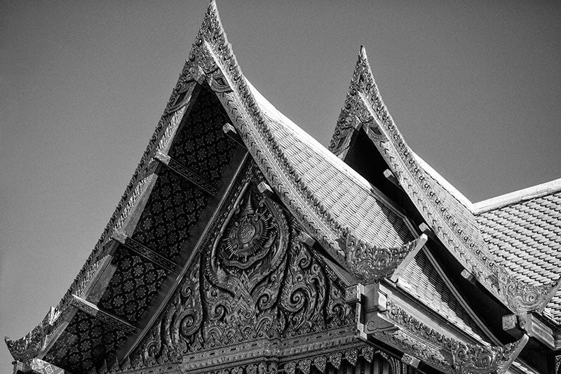Black and white detail photograph of the distinct roof peaks on the ornate red and gold Thai Pavilion, at Olbrich Botanical Garden in Madison, Wisconsin.