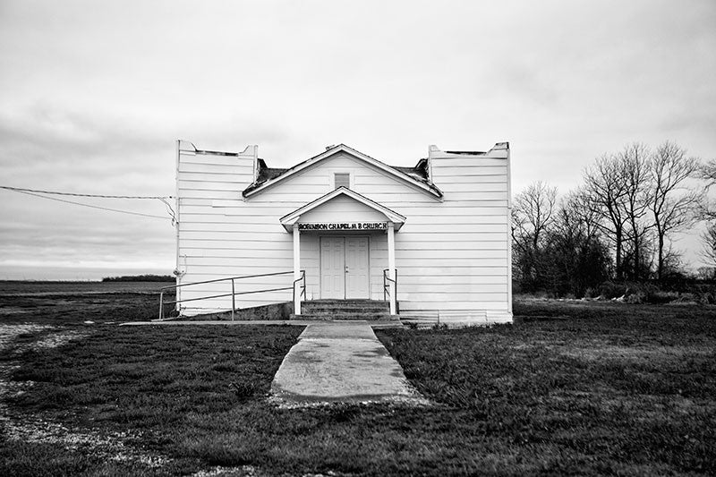 Black and white photograph of a small southern church surrounded by the flat Delta landscape.