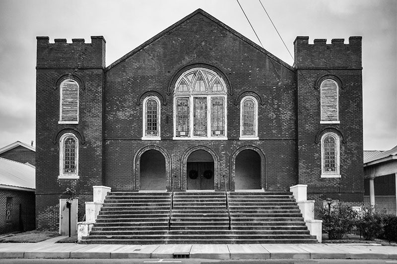 Black and white photograph of a historic red brick church in downtown Clarksdale, Mississippi.