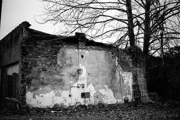 Black and white photograph of an abandoned and boarded-up building in the birthplace of the blues, Clarksdale, Mississippi.