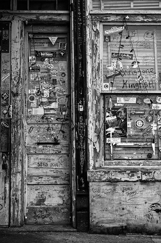 Black and white photograph of the grungy doors at the entrance of a blues club in Clarksdale, Mississippi, the heart of the Mississippi Delta blues region.