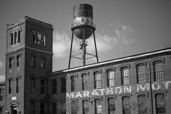 Black and white photograph of the Marathon Motor Works factory in Nashville, Tennessee. Built in 1881 to house the Phoenix Cotton Mill, the Nashville factory was used to manufacture automobiles from 1910 until 1914. The Marathon name was fitting with a Grecian craze that swept the country at the time.