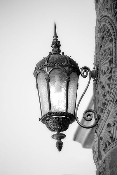 Black and white architectural detail photograph of a lamp on the red sandstone exterior of the old Bexar County Courthouse in San Antonio, which opened in 1896.