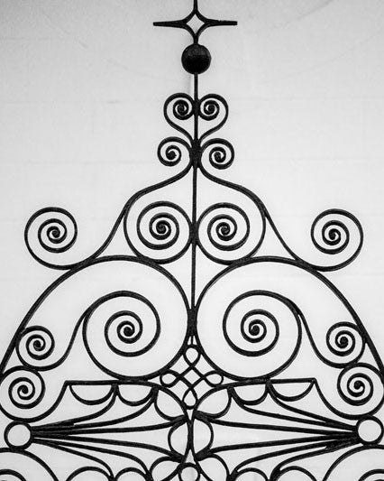Black and white photograph of beautifully decorative ironwork in Charleston, South Carolina, a city known for a long history of fine ironwork in its architecture and fences.