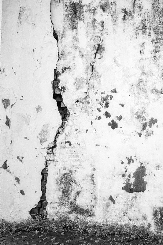 Black and white architectural detail photograph of a crack on the white-washed exterior wall at the old Charleston Jail, which was built in 1802 and remained in service until 1939.