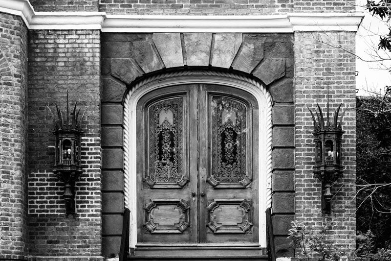 Black and white architectural photograph of fancy glass and wood doors of a large, historic mansion, near the battery on Meeting Street in Charleston, South Carolina. 