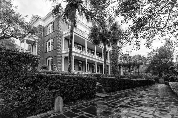 Black and white photograph of Charleston's Calhoun Mansion in the early morning after a rain shower, as seen from Meeting Street. 