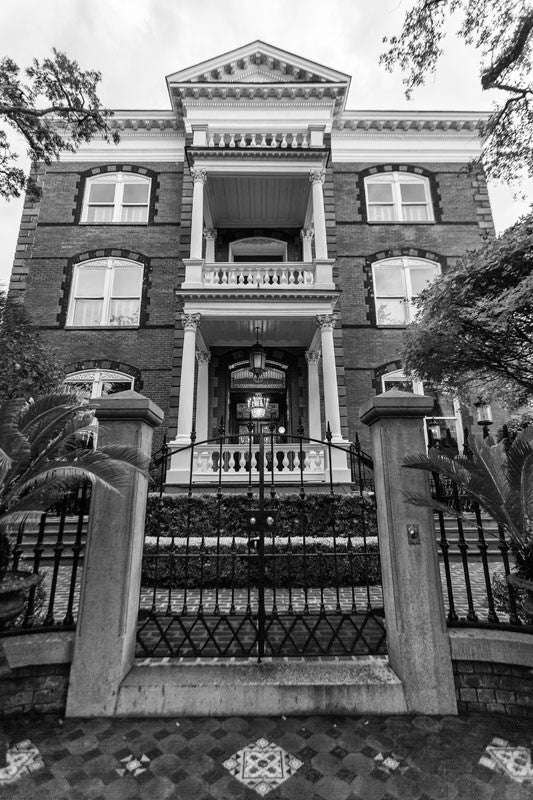 Black and white photograph of Charleston's Calhoun Mansion, as seen looking up from the sidewalk outside the entry gate. 