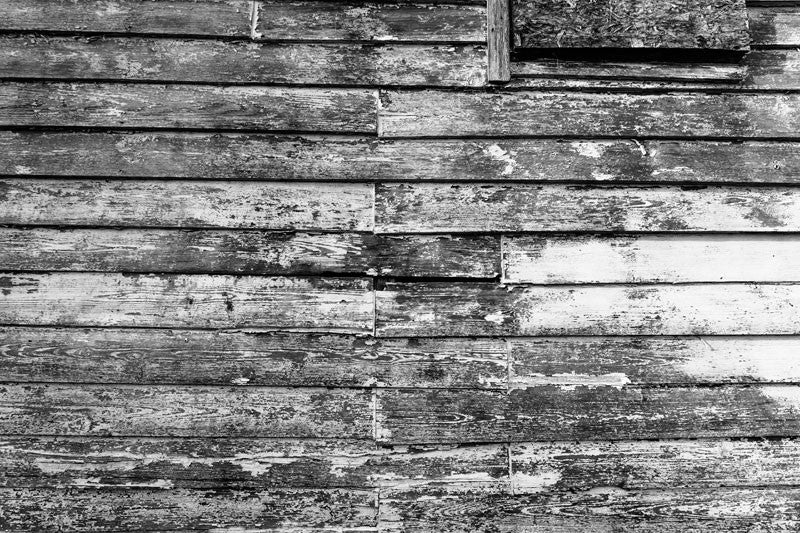Black and white photograph of textured and weathered wood on the side of an old house in Charleston, South Carolina.