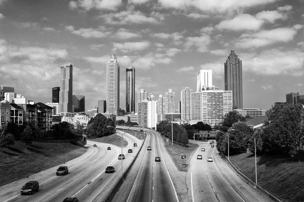 Black and white photograph of the downtown Atlanta skyline as seen from the Jackson Street Bridge. Not only is this a perfect and popular spot to photograph the skyline, it's recognizable as the viewpoint used on one of the posters to promote the TV series "The Walking Dead."
