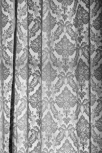 Black and white photograph of lace curtains in the old lighthouse keeper's residence at the St. Augustine Lighthouse in Florida. 