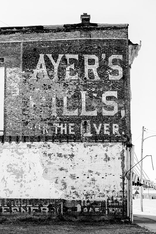 Black and white photograph of a historic hand-painted wall ad for "Ayer's Pills for the Liver," probably dating to about 1900, on an old riverfront building in Cairo, Illinois.
