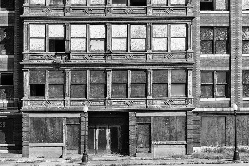 Black and white photograph of beautiful, abandoned commercial building Cairo, Illinois, with the words "Special Offer" painted on the front. The pressed tin embellishments give the building a lovely, ornate archaic quality. It would look right at home in an Edward Hopper painting.