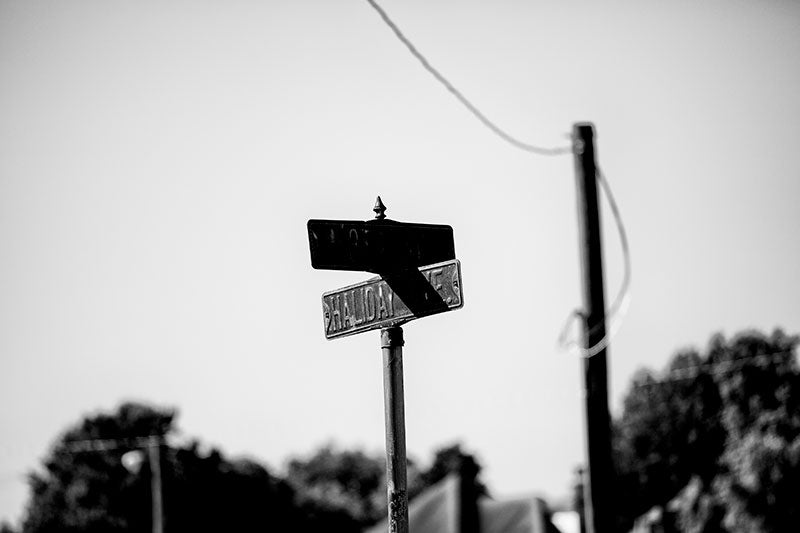 Black and white photograph of a rusty street sign for Haliday Ave in the city of Cairo, Illinois.