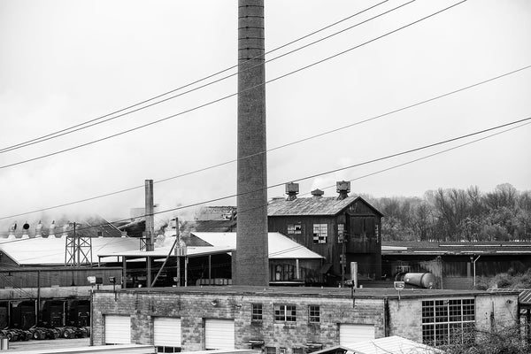 Black and white photograph of a beautifully grimy industrial plant with a very tall brick chimney and broken windows, photographed in Chattanooga, Tennessee.
