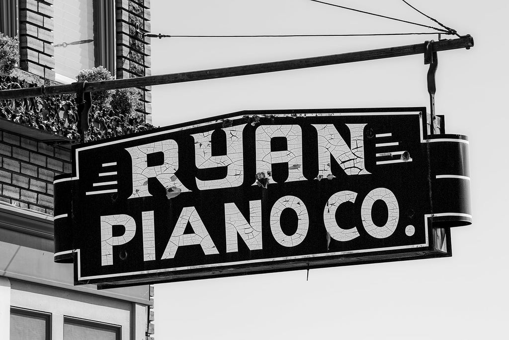Black and white photograph of the now closed Ryan Piano Co. in beautiful downtown Florence, Alabama. The sign has nice craquelure pattern in the paint of the letters. The business has been closed since at least 2001.
