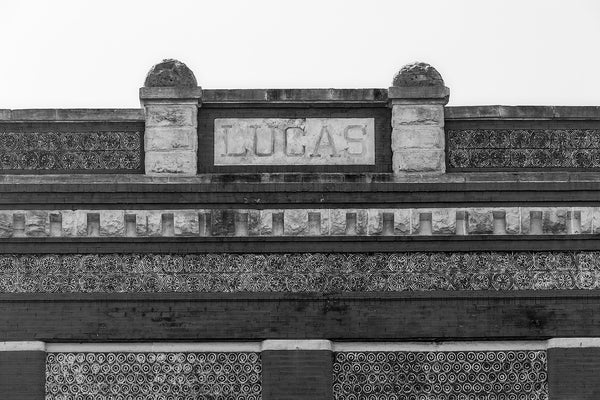 Black and white architectural detail photograph showing the roofline and designs and patterns on the front of the historic Lucas building in downtown Florence, Alabama.
