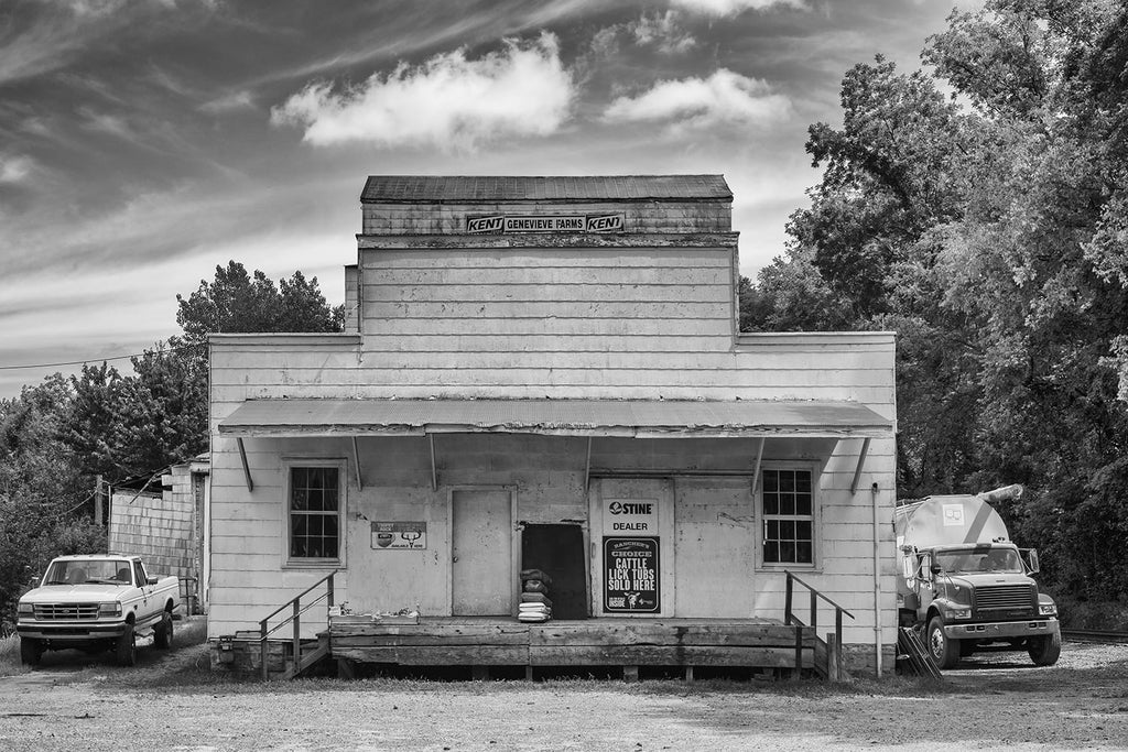 Black and white architectural photograph of an old, wooden agricultural feed store building in the American midwest.