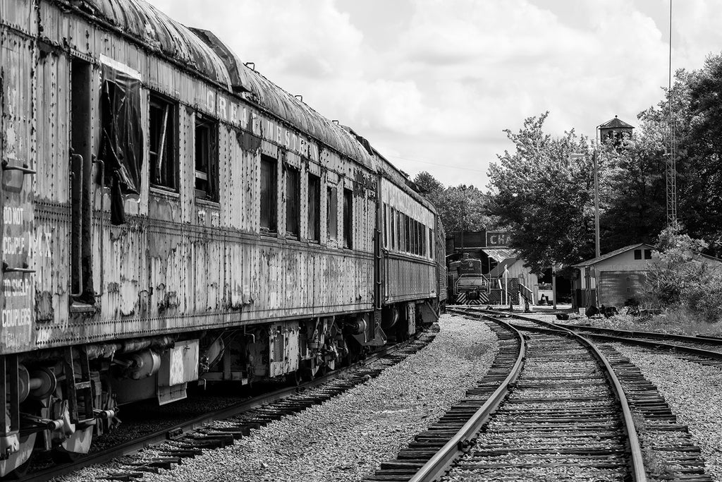 Black and white Photo of Rusty Abandoned Trains Sitting on Railroad Tracks