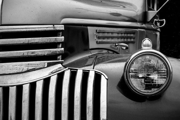 Black and white fine art photograph of the stylish curves around the grill and headlight of a vintage 1947 Chevrolet.