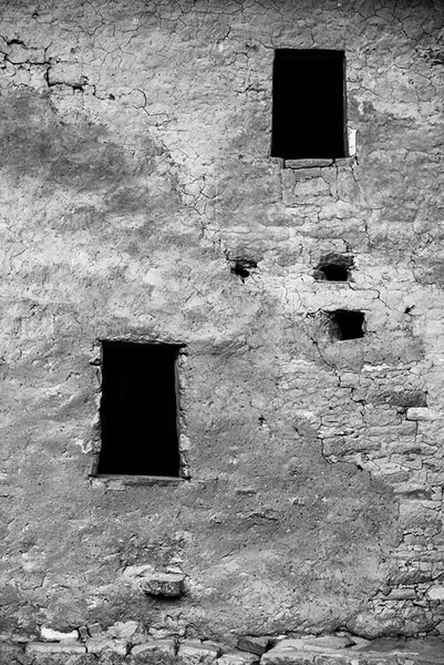 Black and white fine art photograph of a beautifully textured wall with two windows at the ancient Native American dwellings at Mesa Verde in Colorado.