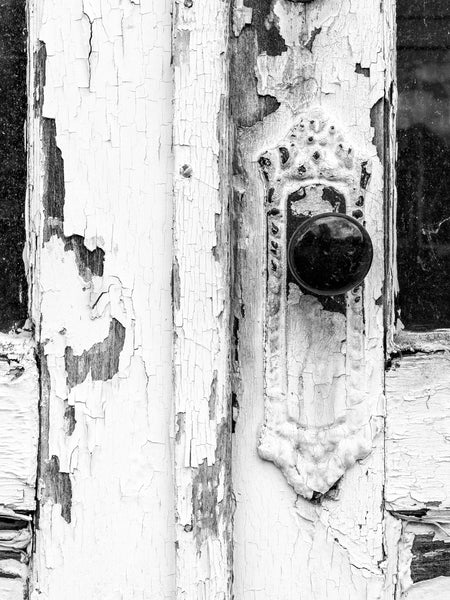 Black and white close-up photograph of the front doors of a vacant old country store.