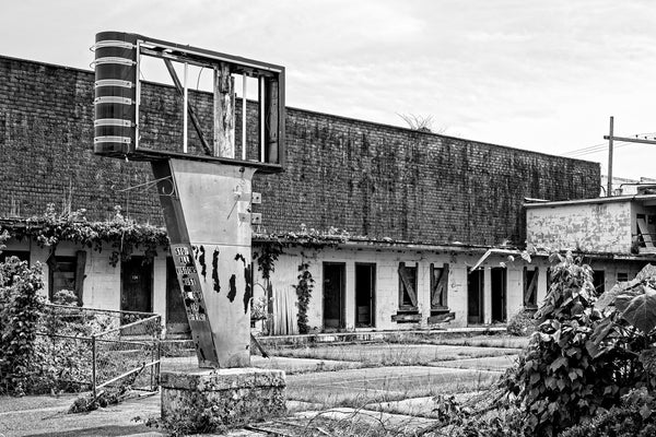 Black and white photograph of an abandoned motel with a broken sign in the Mississippi Delta