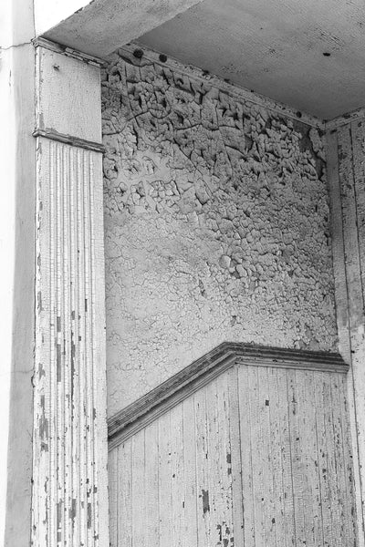 Black and white detail photograph of cracked and peeling paint on the entry to a historic building in downtown Selma, Alabama.