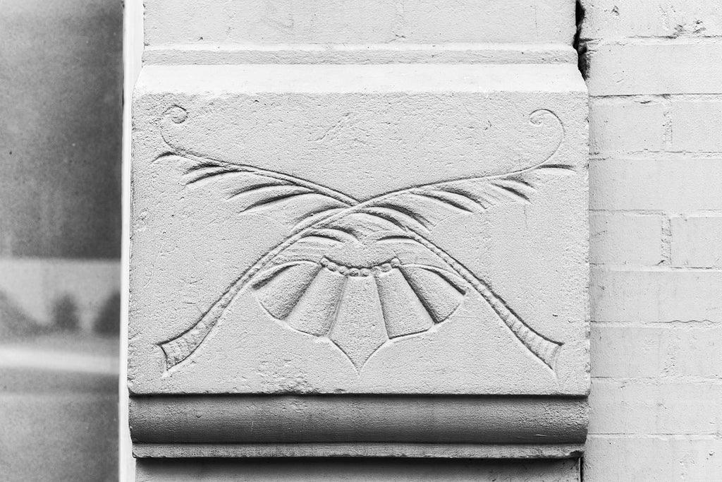 Black and white photograph an architectural detail of a floral impression in the exterior of a historic building in Nashville. 
