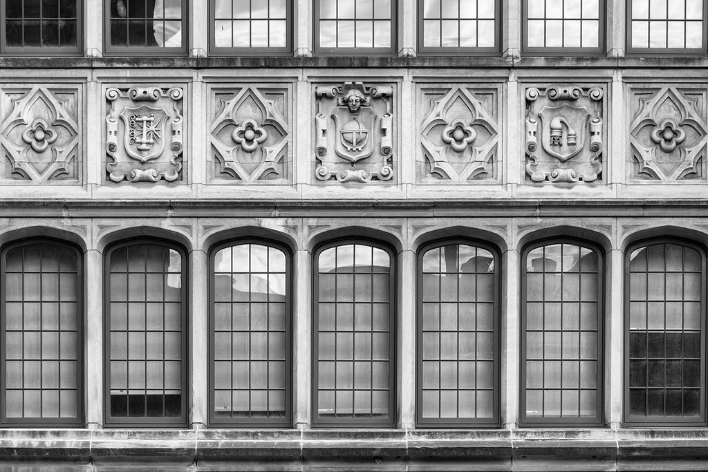 Black and white photograph of the carved stone symbols over the front entrance to Nashville's historic Hume-Fogg High School, which merged from two schools in 1912, with roots back to 1855. Hume-Fogg's notable alumni include the late entertainer Dinah Shore and 1950s pin-up model Bettie Page. 