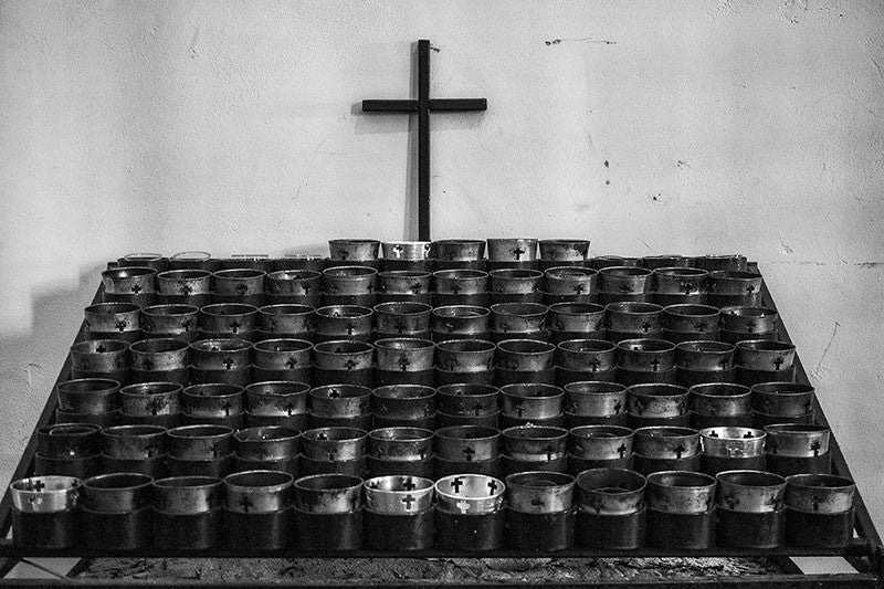 Black and white photograph of candles inside Mission San Jose, an old Spanish Catholic mission founded in 1720, with the church built in 1768. Along with the other San Antonio missions, Mission San Jose is a UNESCO World Heritage site.