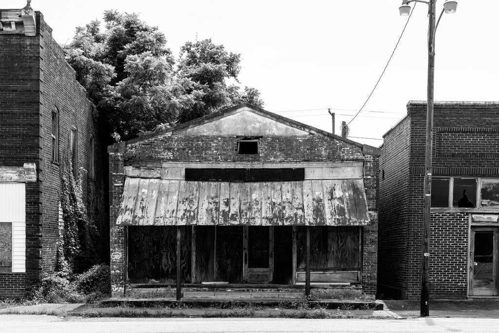 Black and white photograph of the long-abandoned Williams Hardware and Grocery in Pamplin City, Virginia. The entire Main Street of Pamplin City is abandoned. The old general store was owned by the Williams brothers for 30 years. Harry was also the local Postmaster. Woodrow was a professional baseball player with the Brooklyn Dodgers and Cincinnati Reds.