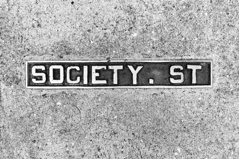 Black and white photograph of a Society Street sidewalk sign in historic Charleston, South Carolina. 
