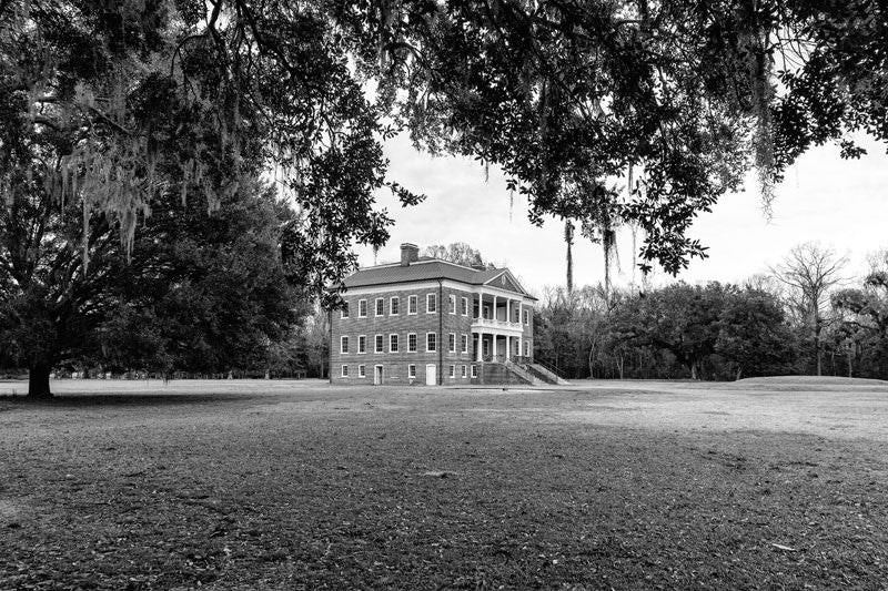 Black and white photograph of Drayton Hall, nine miles outside Charleston, South Carolina. Drayton Hall was built about 1740, and is the only South Carolina plantation home to survive the Revolutionary War and the Civil War intact. The house is now held in a state of preservation, maintained but not restored, which means that original paint, woodwork, and carved ceilings can still be seen.