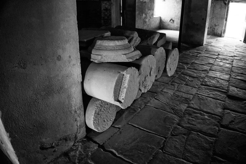 Black and white photograph of old stone columns stacked in the basement of Drayton Hall since at least the 1870s. 