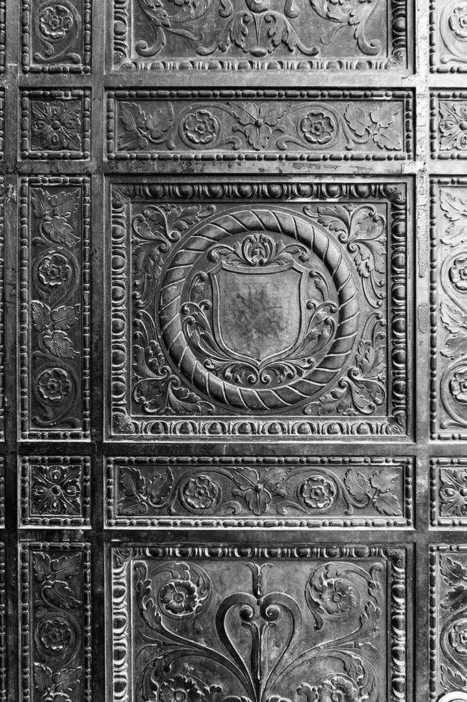Black and white photograph of an ornately decorated bronze door in St. Augustine's old town neighborhood.