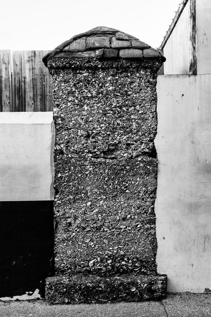 Black and white photograph of an old coquina wall in St. Augustine, Florida. It's the last remaining structure from that development. Coquina is a form of sedimentary rock made of mollusk shells that was mined and quarried for hundreds of years in the Caribbean and Florida.