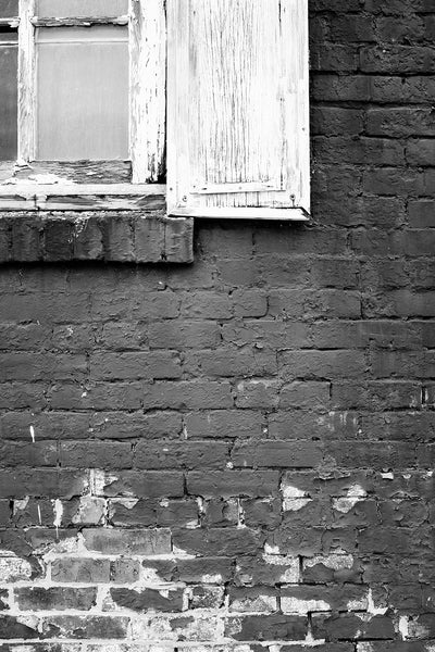 Black and white architectural detail photograph of the painted bricks and wooden shutters on the outside of the old Delta Feed Company in Greenwood, Mississippi.