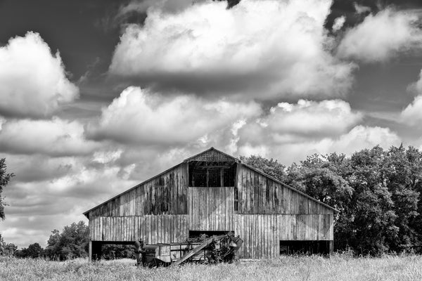 Black and white farm landscape photograph featuring a huge wooden barn built around 1900.