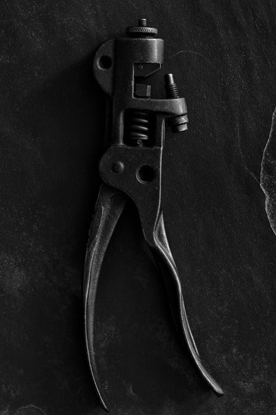 Black and white detail photograph of a pair of antique Morrill Apex Saw Set Pliers, circa late 1800s. These pliers were used to straighten the teeth of says, particularly used in the logging industry.