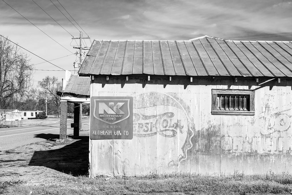Black and white photograph of an old cotton gin building located on Highway 19 in Nutbush, Tennessee, Tina Turner's birthplace. The side of the cotton gin features a vintage Pepsi-Cola sign dating between 1906 and 1940. This is probably the "gin house" mentioned in "Nutbush City Limits."