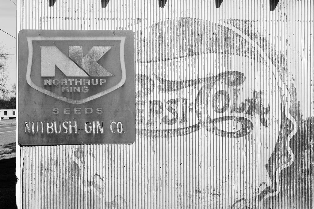 Black and white photograph of Vintage Ads on an Old Southern Cotton Gin Building