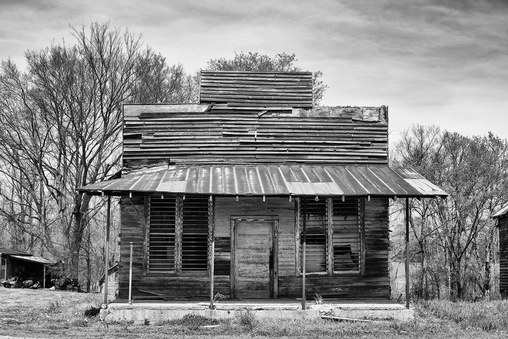 Black and white architectural photograph of an old, abandoned commercial building, most likely a storefront.