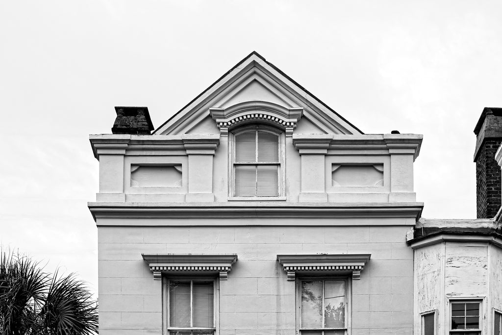 Black and white photograph of a historic house in Charleston with architectural details that are reminiscent of happy smiling eyes.