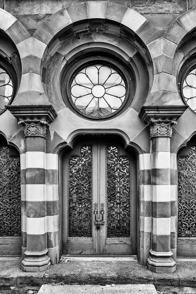 Black and white photograph of the entry doors and round window on the front of the historic Farmers and Exchange Bank built circa 1853 in Charleston.