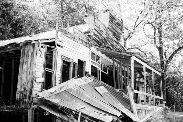 Black and white photograph of an abandoned and collapsing general store building in an old mining community ghost town now called Rush Historic District. This old general store was built between around 1900 to accommodate the miners and their families.