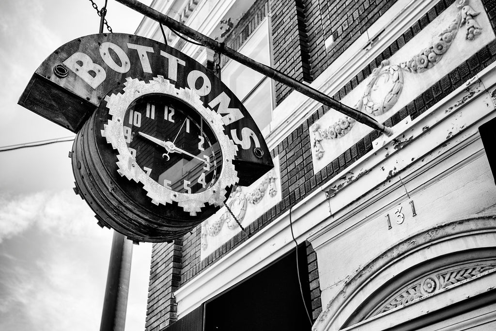 Black and white photograph of a historic vintage clock sign for Bottoms Jewelers in Bardstown, Kentucky