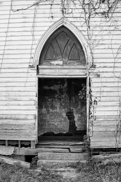 Black and white photograph of the open front entrance of an abandoned 1850s church in a Southern ghost town established along the Mississippi River in the 1820s.