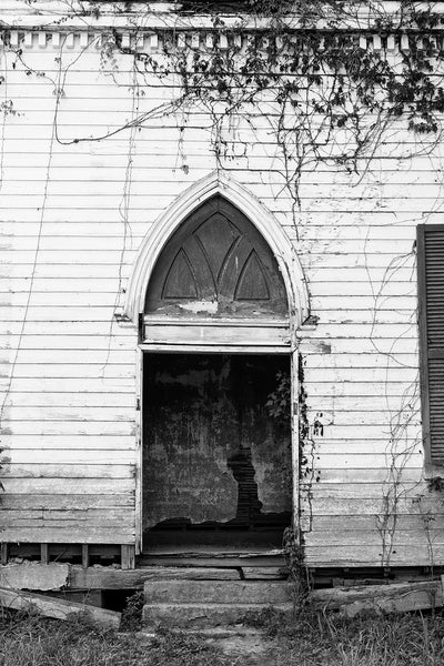Black and white photograph of the front door of a ruined, abandoned 1850s Baptist church in the town of Rodney, Mississippi -- a ghost town established along the Mississippi River in the 1820s. 